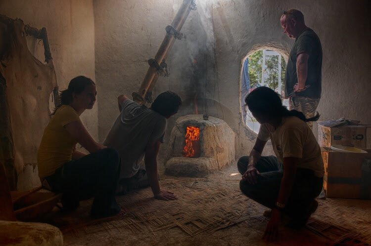 Image of researchers testing the effects of smoke from a burning oven fire in a replica house at Çatalhöyük.